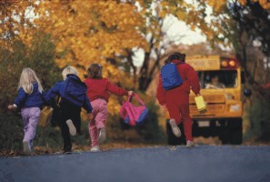 De jeunes écoliers courent vers l’autobus par un matin d’automne.
